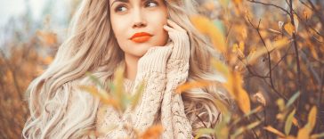 Outdoor fashion photo of young beautiful lady surrounded autumn leaves