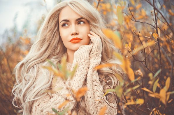 Outdoor fashion photo of young beautiful lady surrounded autumn leaves