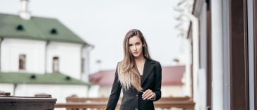 Business girl in a black suit against the background of the city. Near the office buildings.