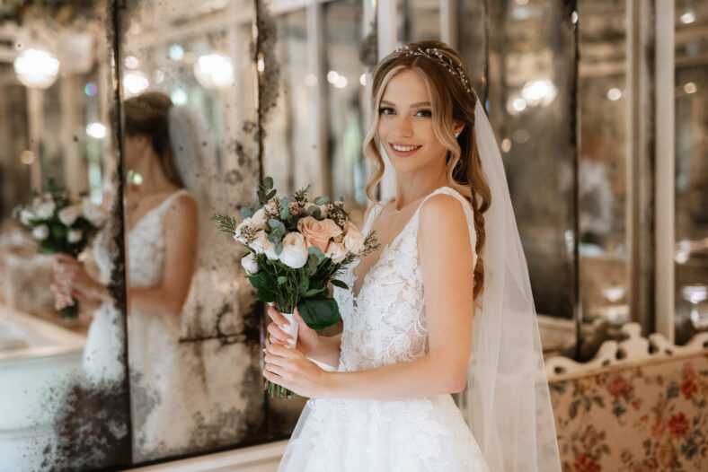 portrait of a bride in a white dress in a bright cafe with mirrors