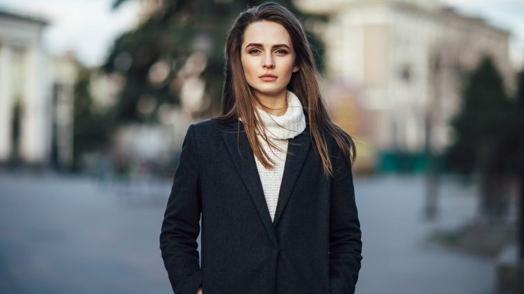 Close up pretty woman portrait posing in the city street at sunset time