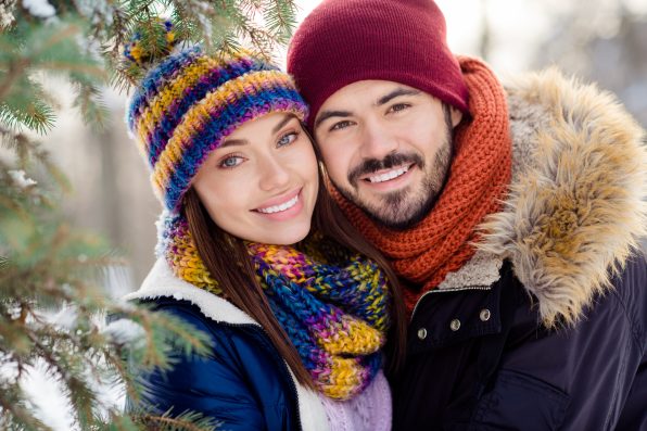 Photo of young attractive couple happy positive smile weekend together forest winter holiday scarf romantic.