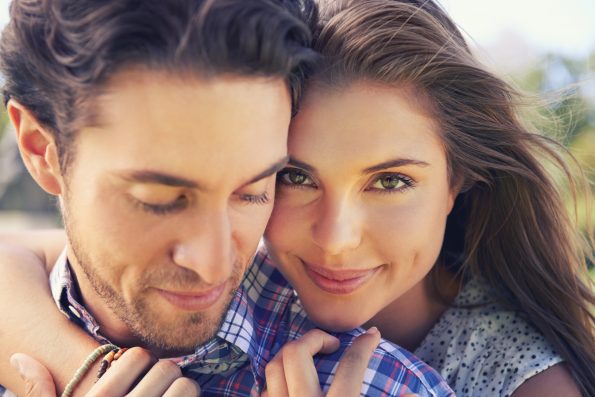 Closeup portrait of a young couple sharing a tender moment while enjoying a day outside