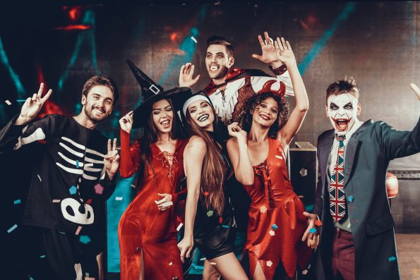 Portrait of Young Smiling People in Scary Costumes. Group of Young Happy Friends Wearing Halloween Costumes having Fun Together and posing for 