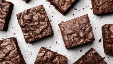 Flat lay composition with fresh brownies on parchment paper. Delicious chocolate pie