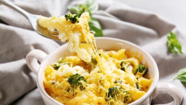 Tasty pasta in ceramic bowl on grey fabric background