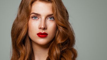 Perfect redhead woman face closeup. Red head girl with curly hairstyle and green eyes. Natural authentic beauty