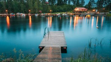 Sweden. Beautiful Wooden Pier Near Lake In Summer Evening Night. Lake Or River Landscape. Riverside