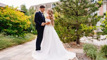 happy newlyweds. the groom and the blonde bride in traditional wedding clothes in a park. wedding fashion and organization of a holiday in the summer in the fresh air.