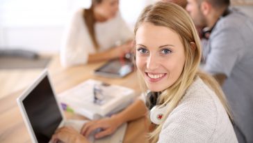 Student girl sitting in class and working on laptop