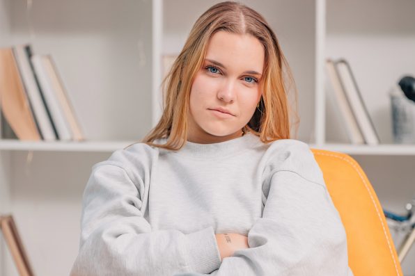 portrait of blue eyed blonde young woman or student at home