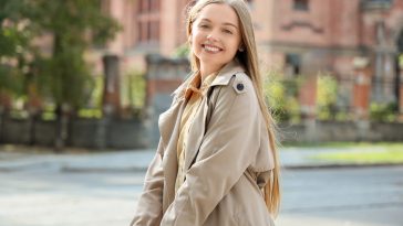 Pretty young woman with umbrella on city street