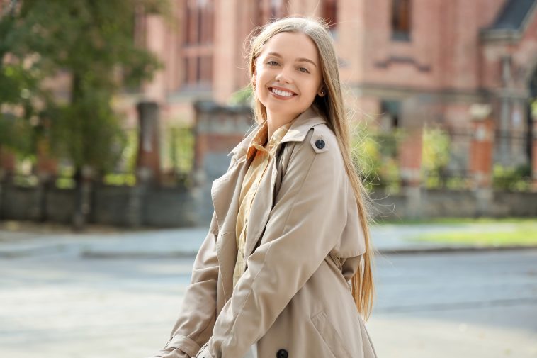 Pretty young woman with umbrella on city street