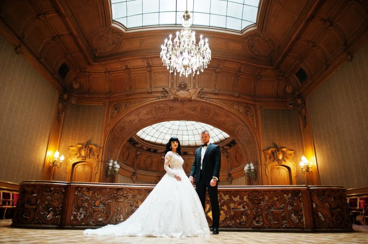 Magnificent wedding pair newlywed at rich wooden royal palace.