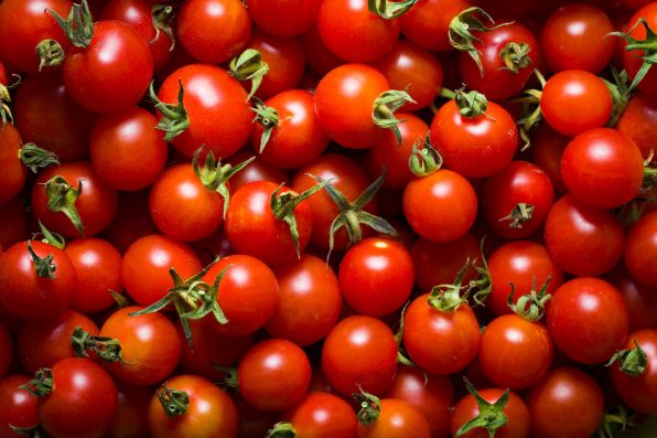 Little red cherry tomatoes nature background.