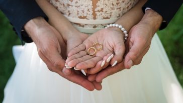 Two golden wedding rings on bride and groom's palms. Wedding rings on the palm