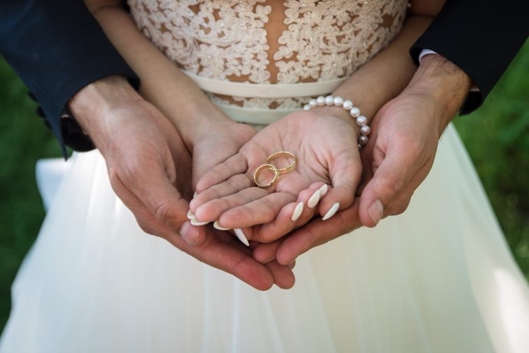 Two golden wedding rings on bride and groom's palms. Wedding rings on the palm