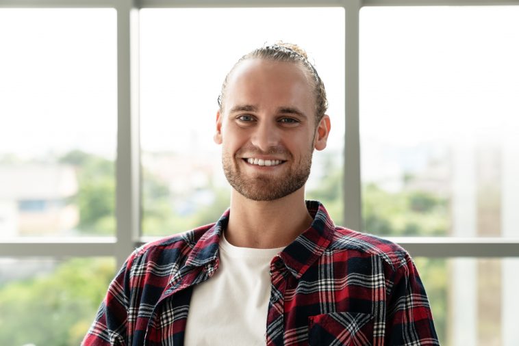 Portrait of young happy short stylish bearded caucasian man or creative designer smiling and looking at camera feeling confident in casual outfit. Headshot of male employee, entrepreneur or student.