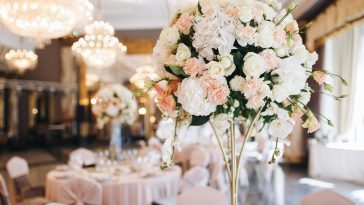 Pink and white wedding bouquet stands in the middle of dinner table