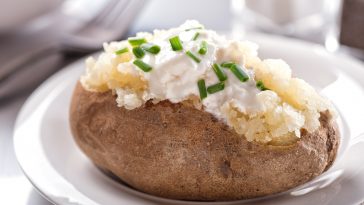 A delicious oven baked potato with sour cream and chives.