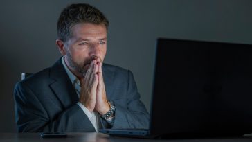 young attractive and surprised workaholic  entrepreneur man working late night using laptop computer in shock and surprise with disbelief face expression in business lifestyle concept