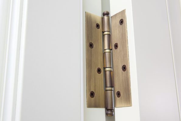 New modern metal door hinges on white wooden doors