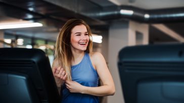 A portrait of a beautiful young girl or woman doing cardio workout in a gym.