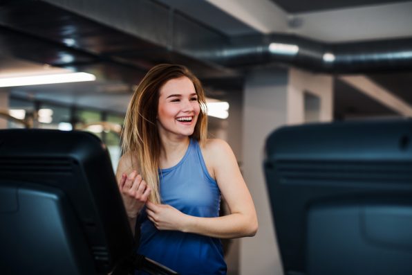 A portrait of a beautiful young girl or woman doing cardio workout in a gym.