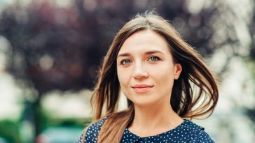 Outdoor portrait of attractive young woman with long brown hair