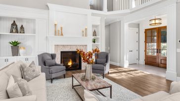 Beautiful living room in new traditional style luxury home. Features vaulted ceilings, fireplace with roaring fire, and elegant furnishings.