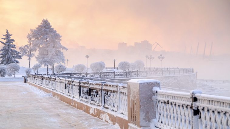 Winter landscape of frosty trees, white snow in city park. Trees covered with snow in Siberia, Irkutsk near lake Baikal. Extremely cold winter