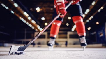 Close up of hockey player skating with stick and puck.