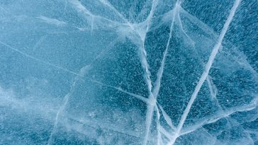 Beautiful blue ice of Lake Baikal with abstract cracks