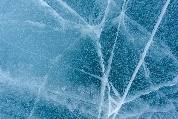 Beautiful blue ice of Lake Baikal with abstract cracks