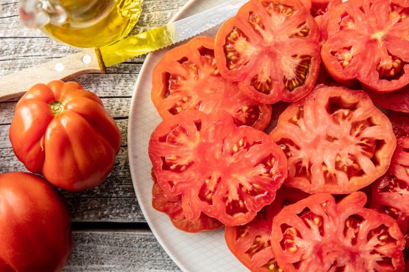 Sliced red beefsteak tomatoes on plate. Top view.