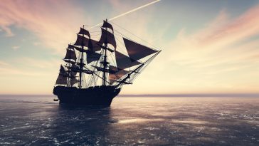 Pirate ship sailing on the ocean at sunset. Vintage cruise