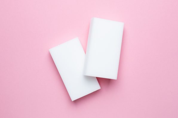 Melamine sponges on pink background, minimalism , white figure, kitchen and home cleaning top view