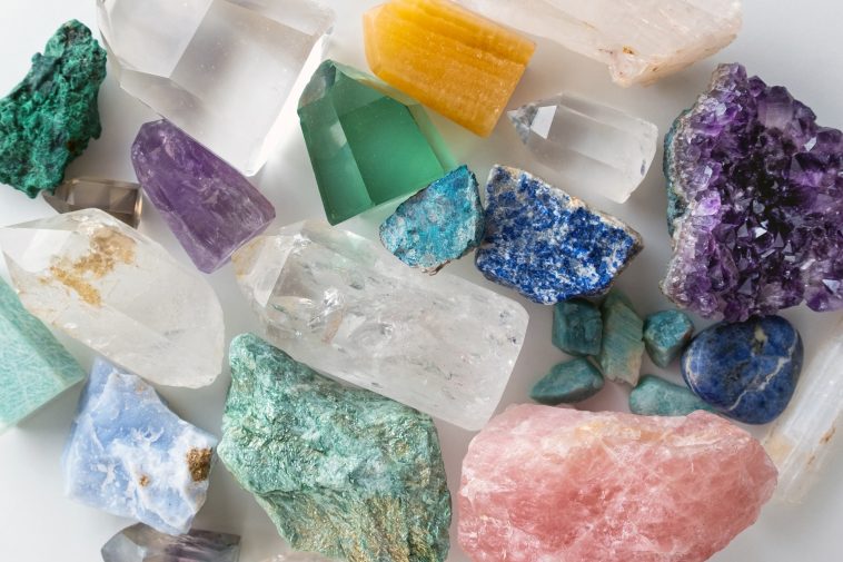 Background of beautiful crystals and colorful gemstones. Flat lay of various gemstones and crystals with violet methyst, rose quartz etc