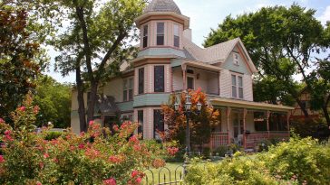 Victorian House with fence and plants