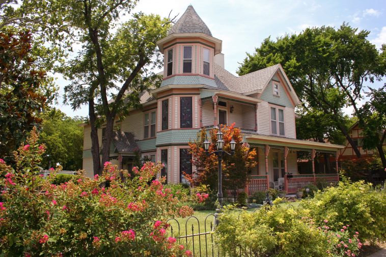 Victorian House with fence and plants