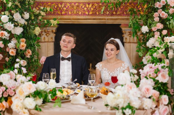 happy bride and groom at the table in the restaurant hall. festive banquet. tradition of celebrating marriage registration. wedding