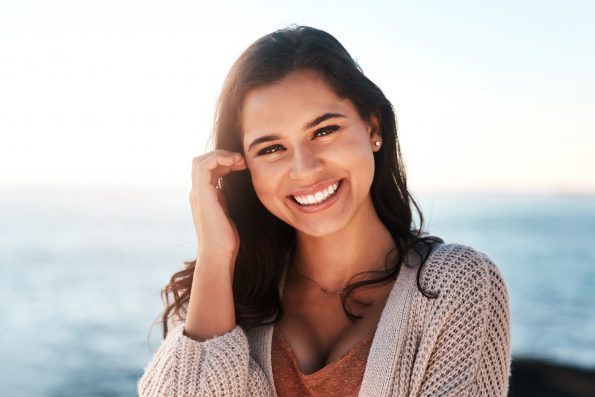 Portrait of a happy young woman enjoying a day at the beach.