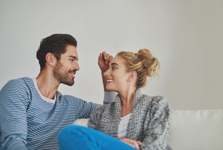 Shot of a young couple enjoying a conversation on their sofa at home.