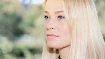 portrait of blonde woman in a park looking to the side