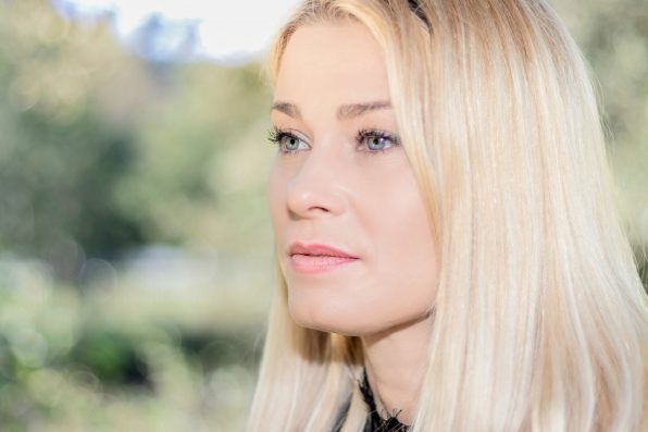 portrait of blonde woman in a park looking to the side