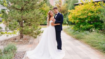 happy newlyweds. the groom and the blonde bride in traditional wedding clothes in a park. wedding fashion and organization of a holiday in the summer in the fresh air.