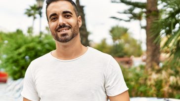 Young hispanic man smiling confident walking at park