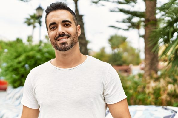 Young hispanic man smiling confident walking at park