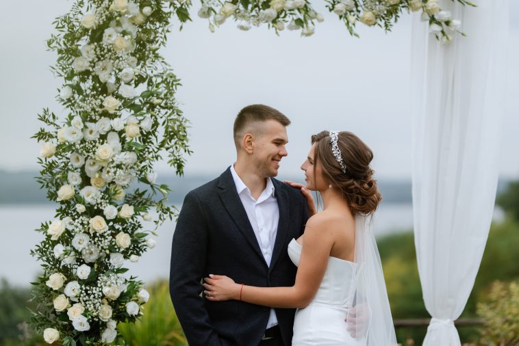 wedding ceremony of the newlyweds in a country cottage on a green hill