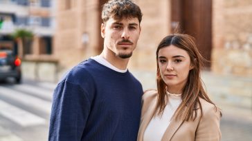 Mand and woman couple standing together with serious expression at street